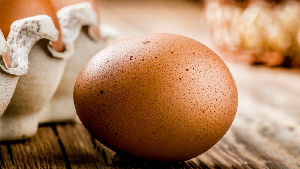коричневое яйцо в крапинку на деревянном столе