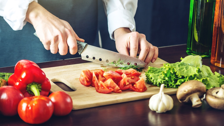 человек режет овощи кухонным ножом