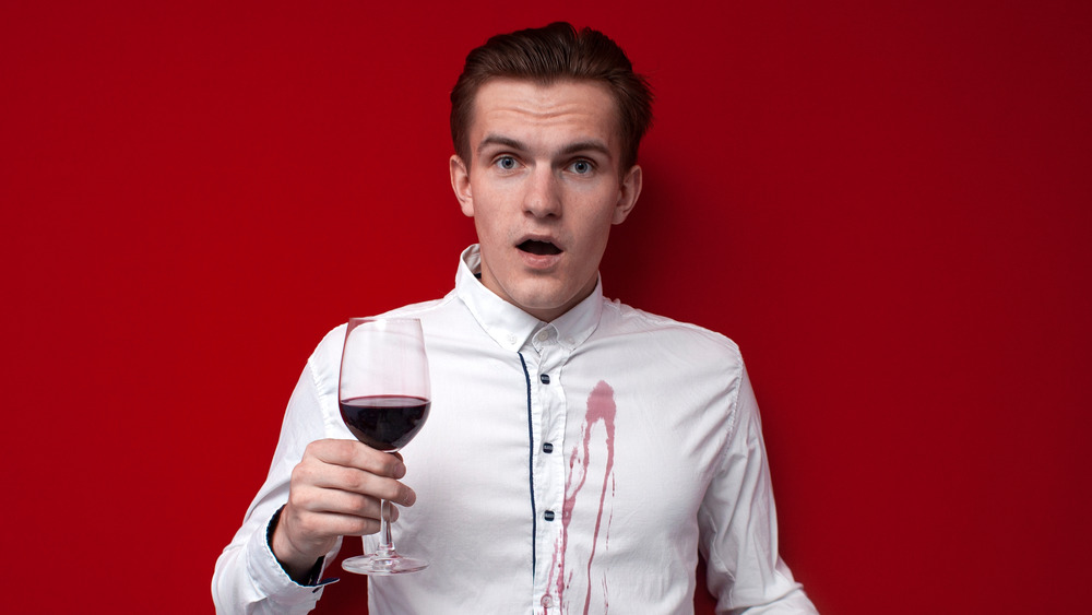Мужчина с пятном от красного вина на рубашке