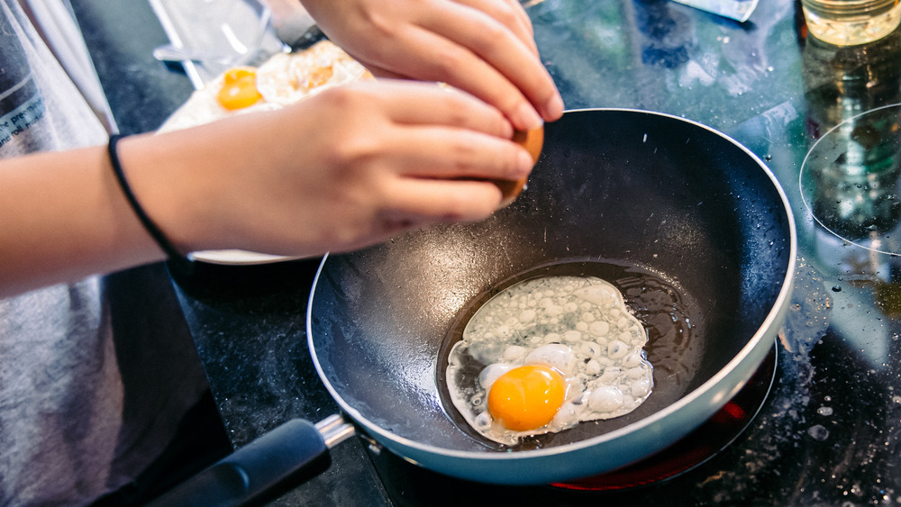 Разбивание яйца на сковороде