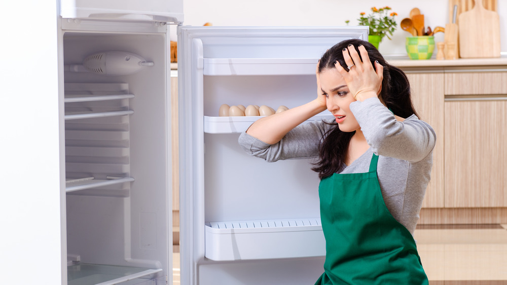 Женщина чистит холодильник