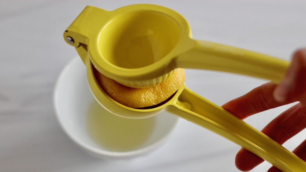 Выжимание лимона с помощью желтой соковыжималки