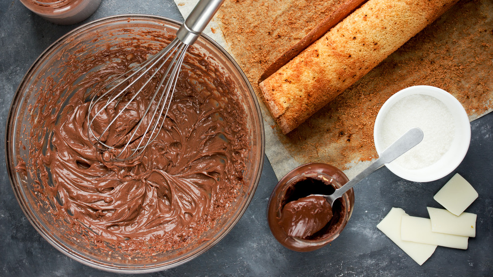 Взбейте в миске шоколадную массу, раскатанный корж, небольшую миску темного шоколада и кусочки белого шоколада.