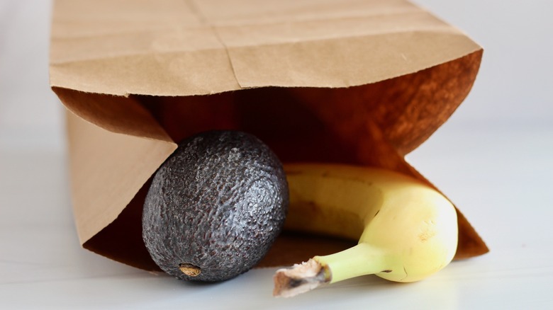 Авокадо и банан в коричневом бумажном пакете