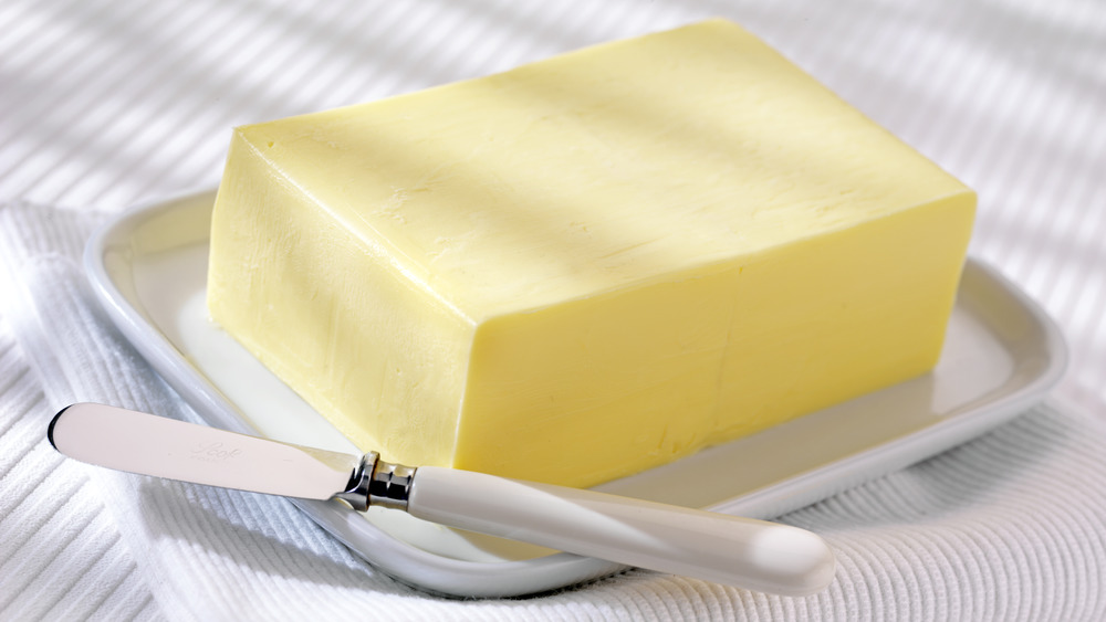 Масло на тарелке с помощью ножа